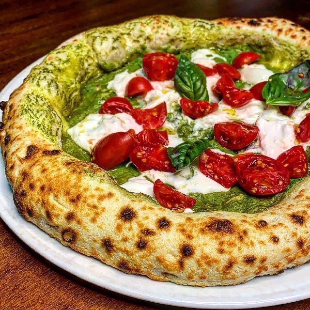 Pizza con base al pesto, burrata, pomodorini e basilico